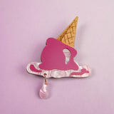 A handcrafted Melted Ice Cream Brooch shaped like a melting cone, with a pink scoop, tan cone, and teardrop charm, set against a light purple background—perfect for adding sweet whimsy to your summer wardrobe.